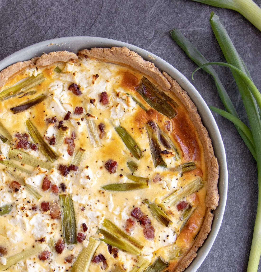 Simple whole grain bacon pie recipe with feta cheese, spring onions, egg mixture.